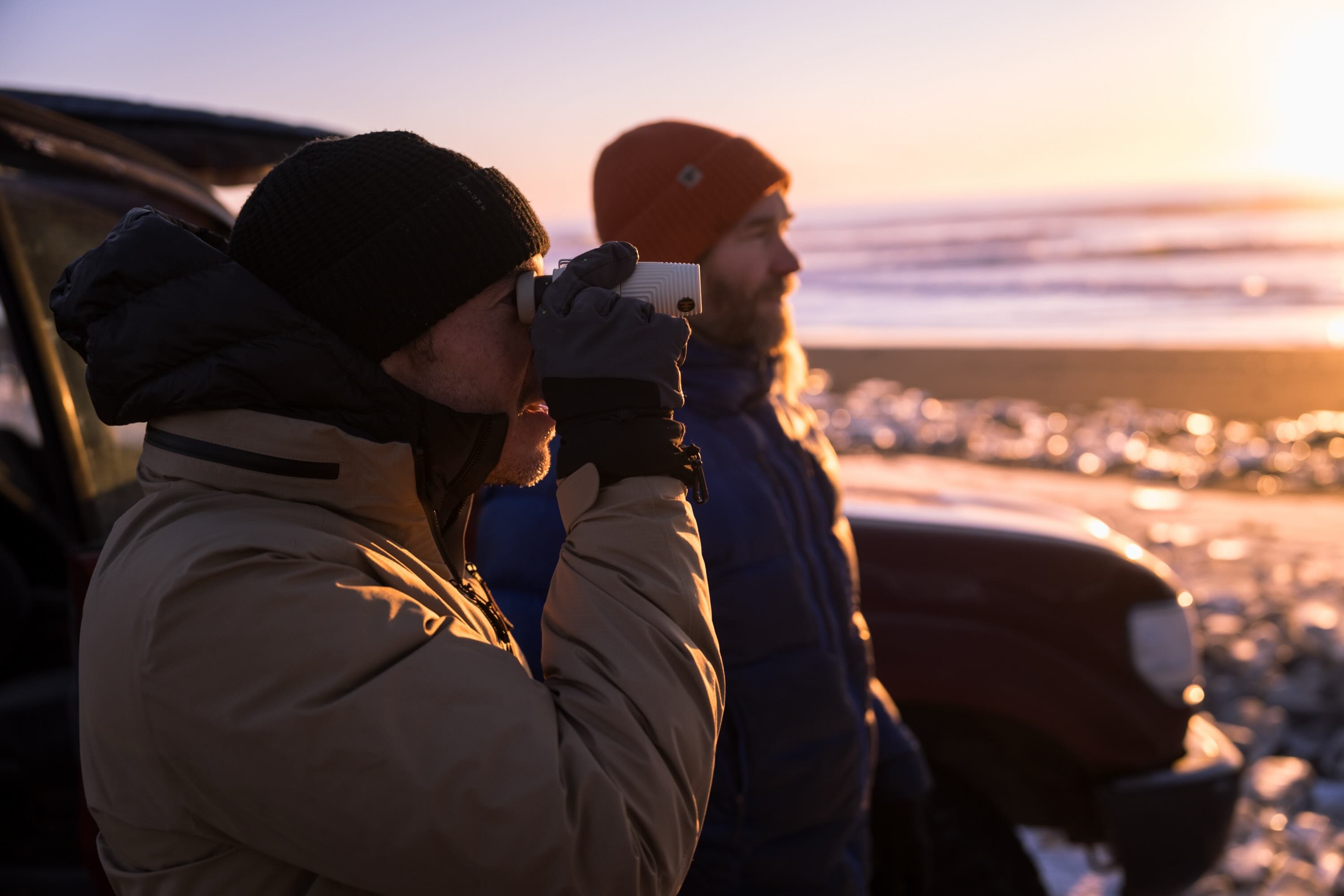 outdoor, Fernglas, Winterjacke, Beanie, Sonnenuntergang am Strand
