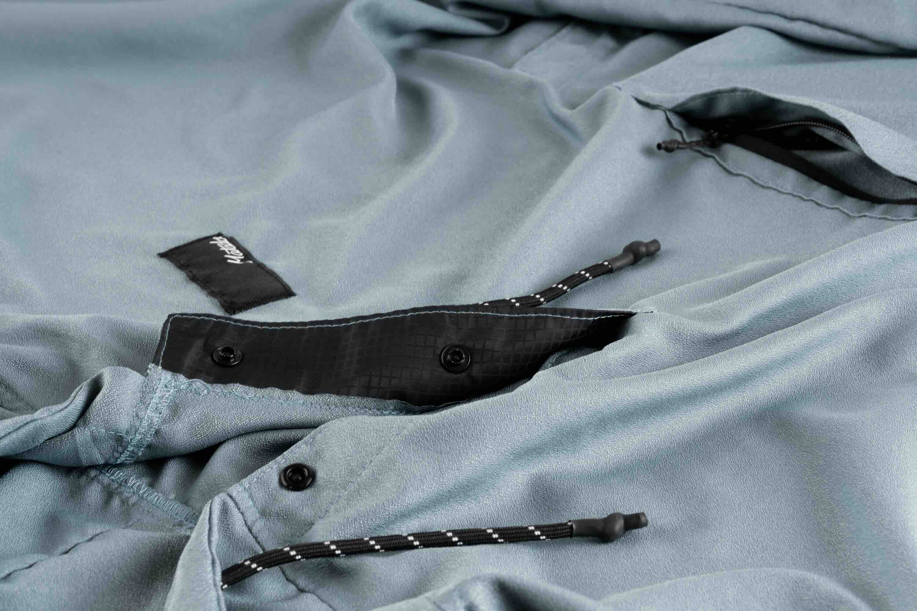 light blue jacket, soft shell, drawcords, zipper pocket, button closure