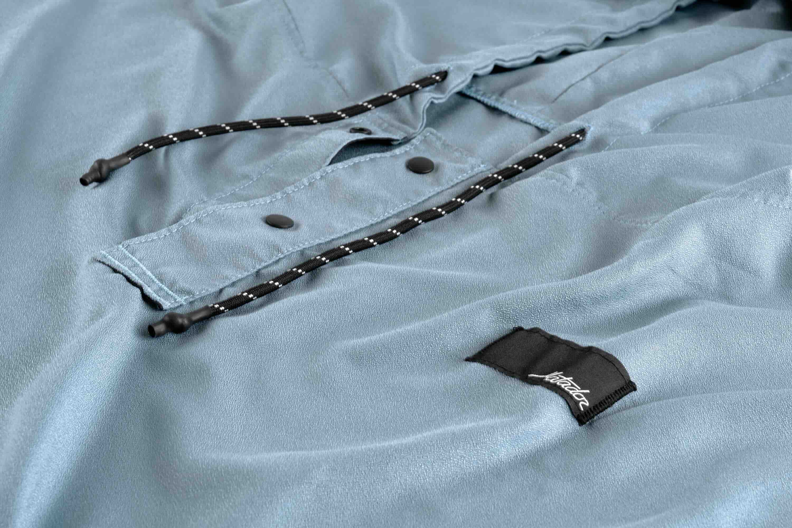 light-blue fabric, drawstring, pocket, button, patch logo