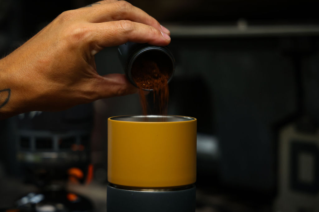 Kaffeemühle, gelbes Gehäuse, zylindrischer Behälter, schwarzer Sockel